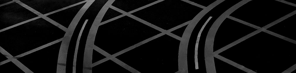 Fotografia em preto e branco de uma estrada com marcações de trânsito.